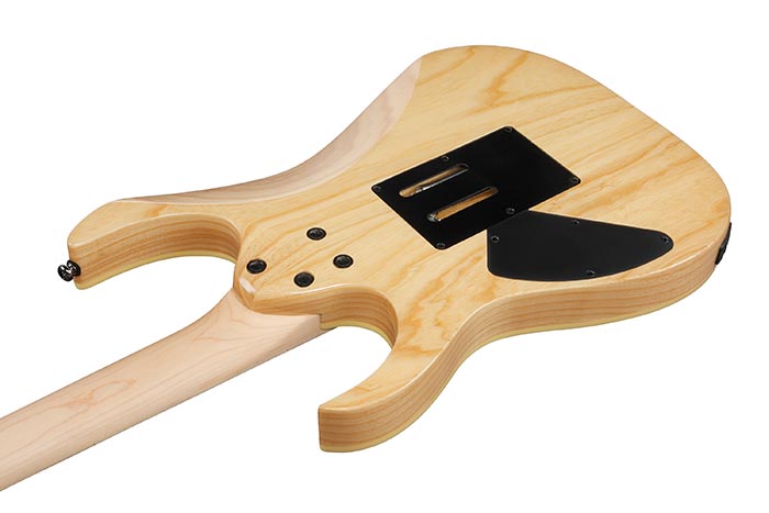 Wooden guitar body with a black pickguard on a white background